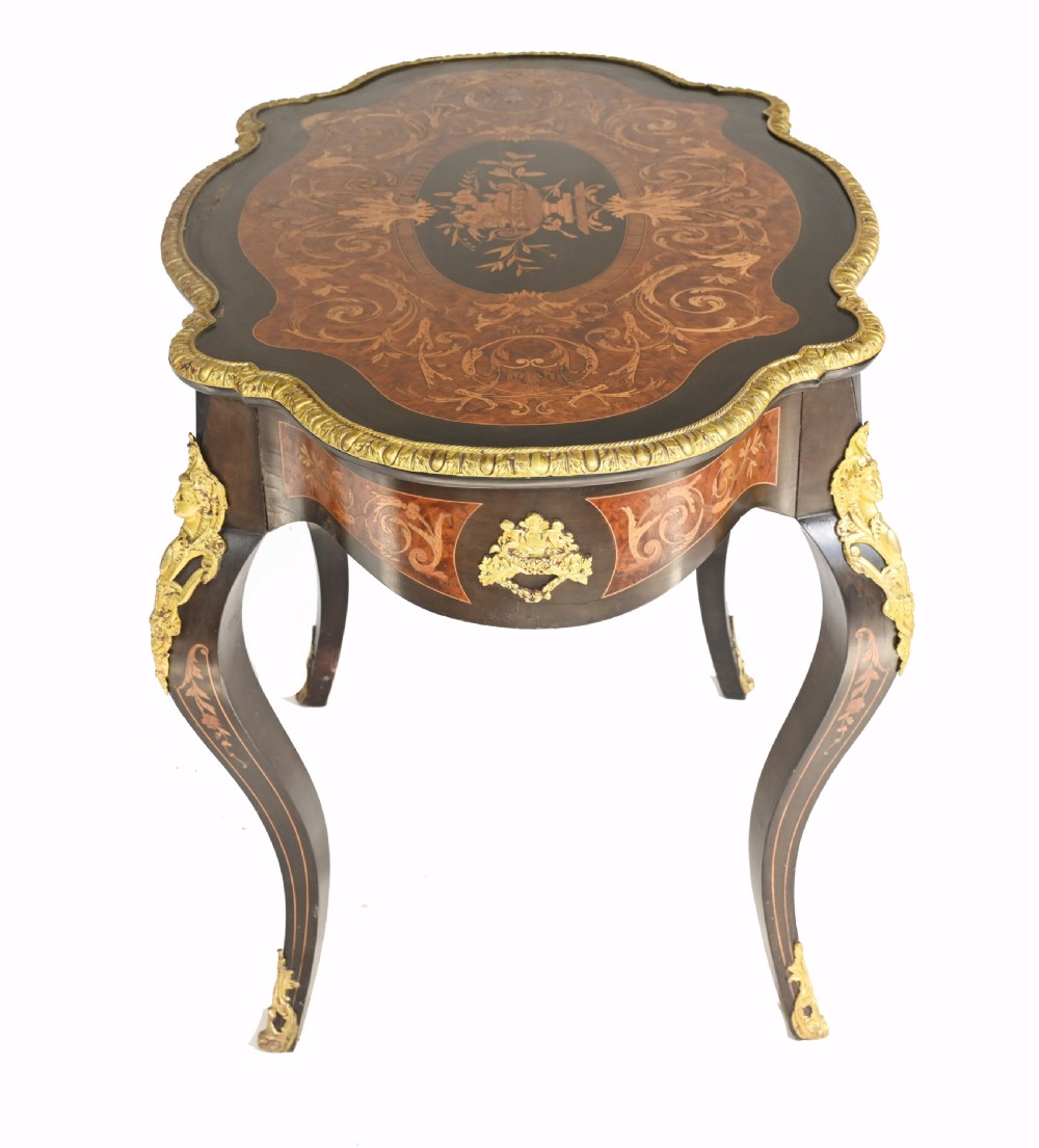 A 19th-century French Louis XV style centre table featuring a serpentine-edged top decorated with floral marquetry inlay, gilt-brass rim mounts, cabriole legs, and a single drawer. View VIII