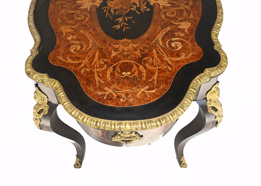 A 19th-century French Louis XV style centre table featuring a serpentine-edged top decorated with floral marquetry inlay, gilt-brass rim mounts, cabriole legs, and a single drawer. View X