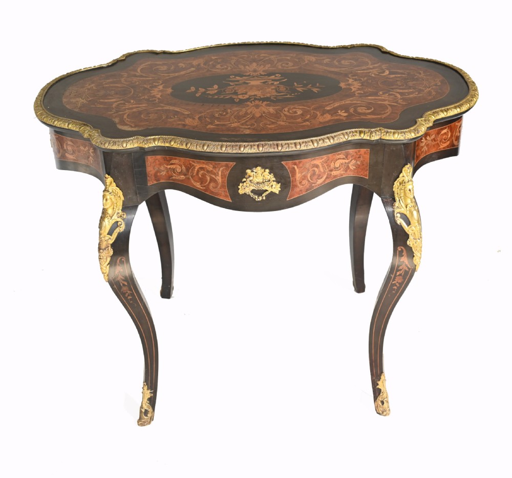 A 19th-century French Louis XV style centre table featuring a serpentine-edged top decorated with floral marquetry inlay, gilt-brass rim mounts, cabriole legs, and a single drawer. View XI