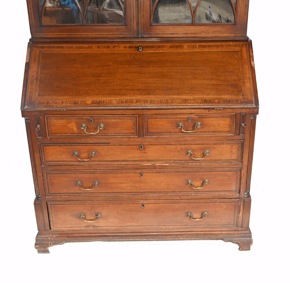 A late 18th-century mahogany bureau bookcase featuring upper astragal glazed double doors with an oval shell marquetry pediment, above a slanted fall-front writing desk and four graduating drawers with brass handles. View III