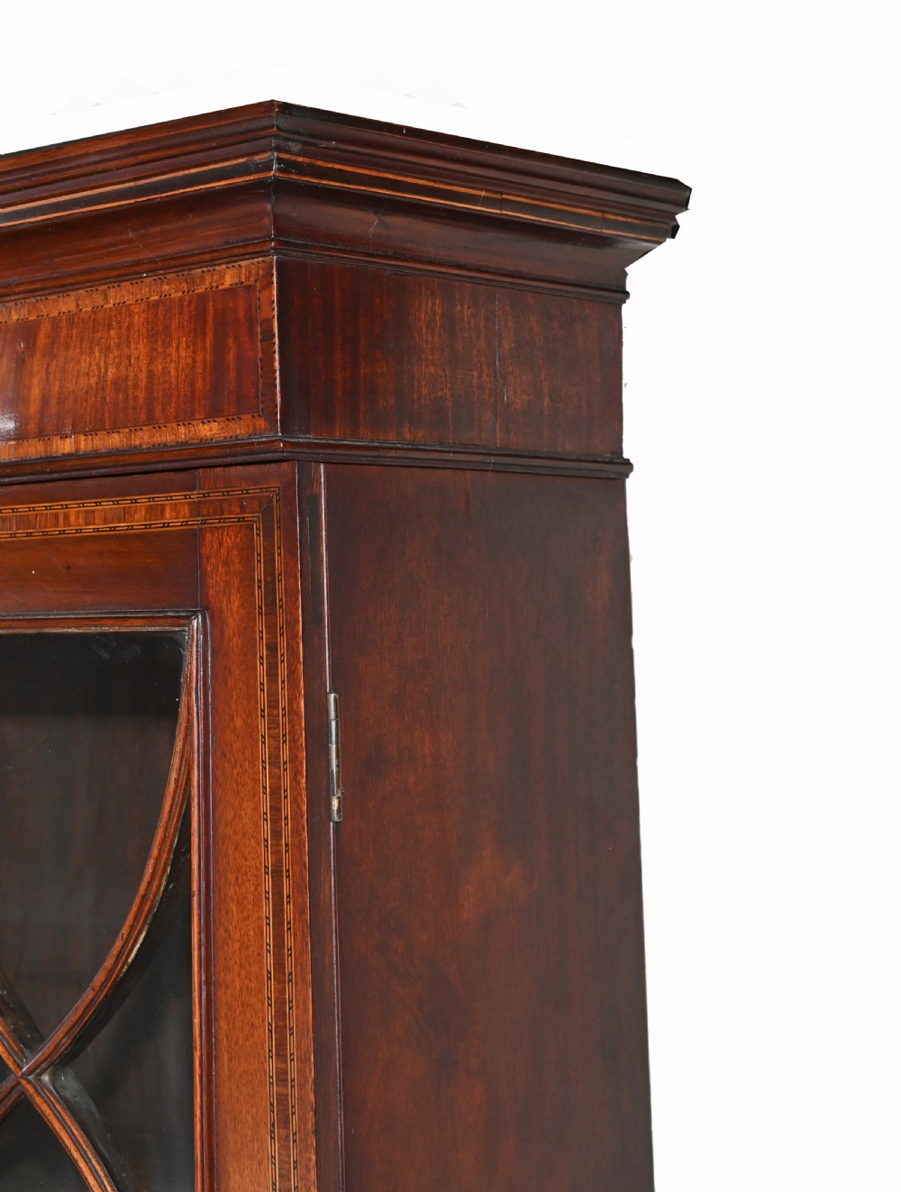 A late 18th-century mahogany bureau bookcase featuring upper astragal glazed double doors with an oval shell marquetry pediment, above a slanted fall-front writing desk and four graduating drawers with brass handles. View X