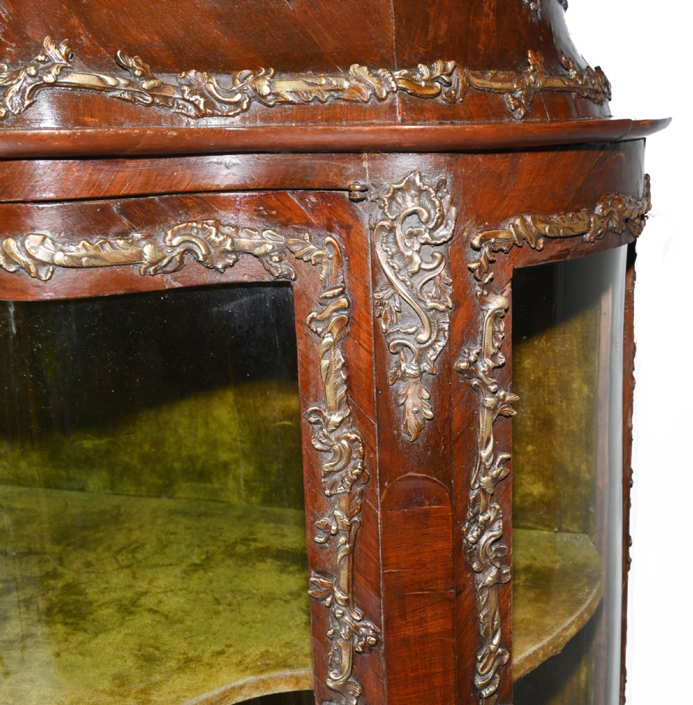 An antique French glazed vitrine cabinet with curved glass panels, floral marquetry inlay on the lower doors, and ornate brass ormolu mounts. View IV