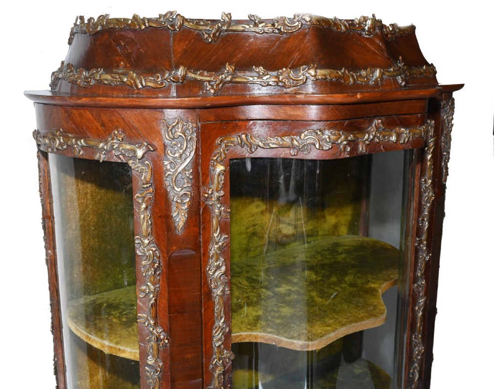 An antique French glazed vitrine cabinet with curved glass panels, floral marquetry inlay on the lower doors, and ornate brass ormolu mounts. View V