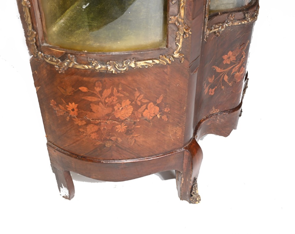 An antique French glazed vitrine cabinet with curved glass panels, floral marquetry inlay on the lower doors, and ornate brass ormolu mounts. View VII