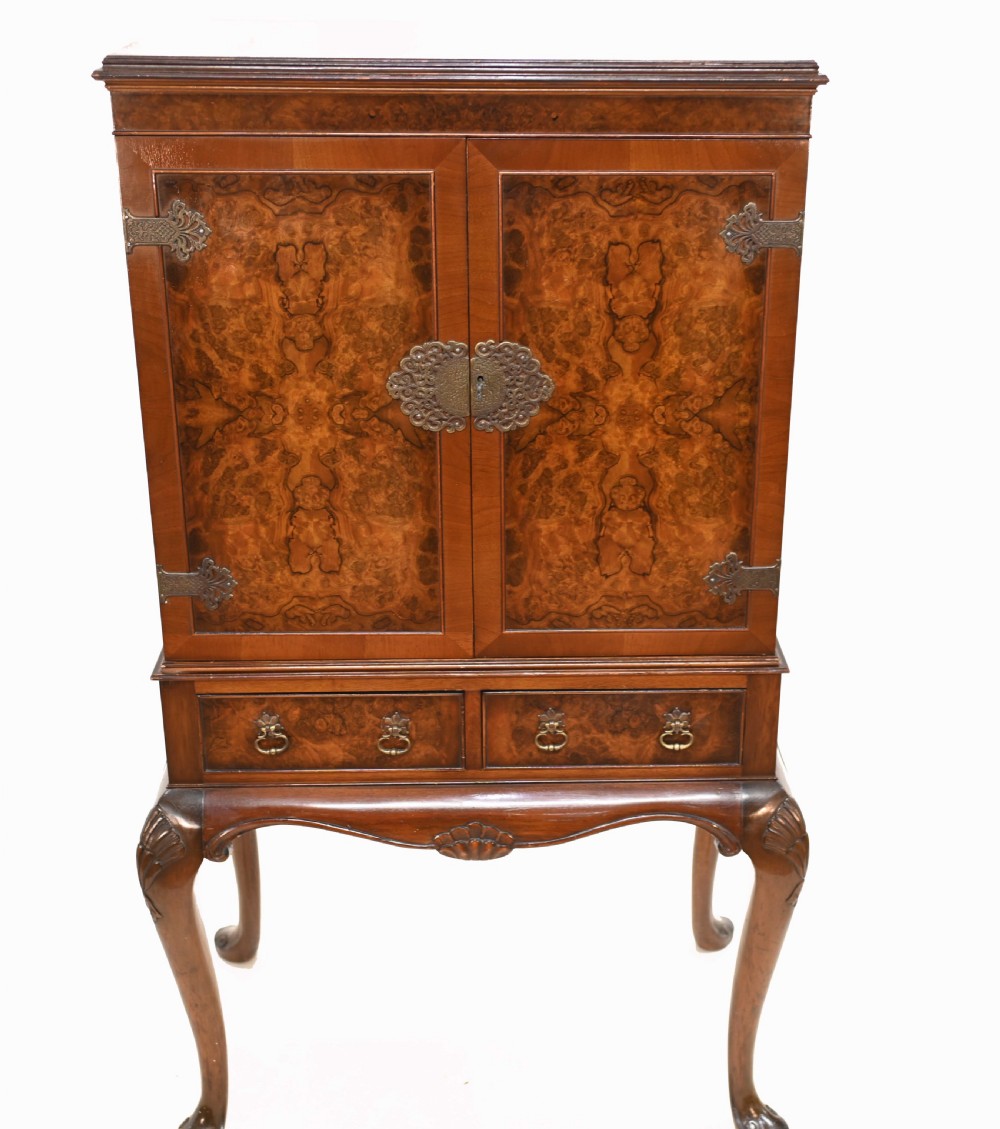 An Art Deco burr walnut drinks cabinet on a carved cabriole leg stand with ornate brass hardware and two lower drawers. View III