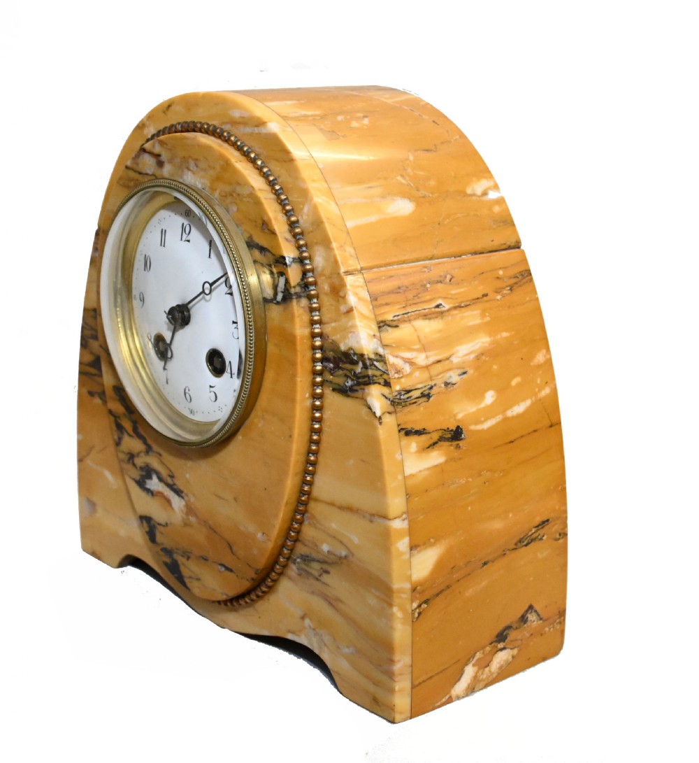 An antique French three-piece garniture set featuring an arched yellow veined marble clock flanked by two matching marble pedestal tazzas. View IX