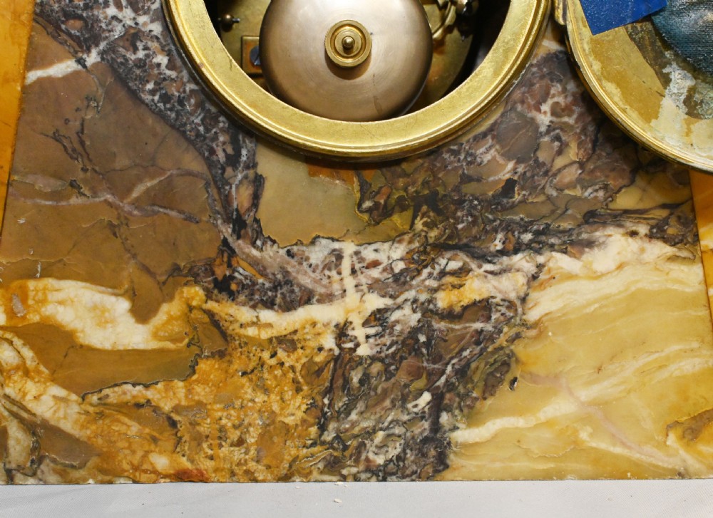 An antique French three-piece garniture set featuring an arched yellow veined marble clock flanked by two matching marble pedestal tazzas. View XIV