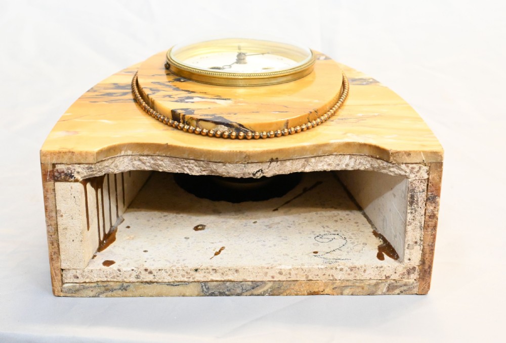 An antique French three-piece garniture set featuring an arched yellow veined marble clock flanked by two matching marble pedestal tazzas. View XVI
