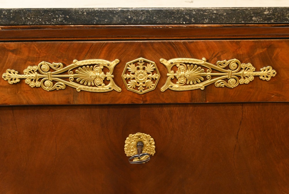 A late 19th-century French Empire mahogany escritoire desk featuring a dark marble top, drop-front writing compartment, three lower drawers, and ornamental gilt-bronze mounts. View VI