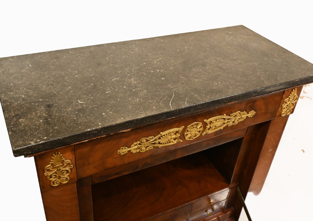 A late 19th-century French Empire mahogany escritoire desk featuring a dark marble top, drop-front writing compartment, three lower drawers, and ornamental gilt-bronze mounts. View XI