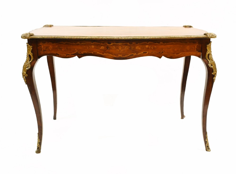 A French style writing table featuring floral marquetry wood veneers, cabriole legs, and ornate gilt-bronze mounts. View VI