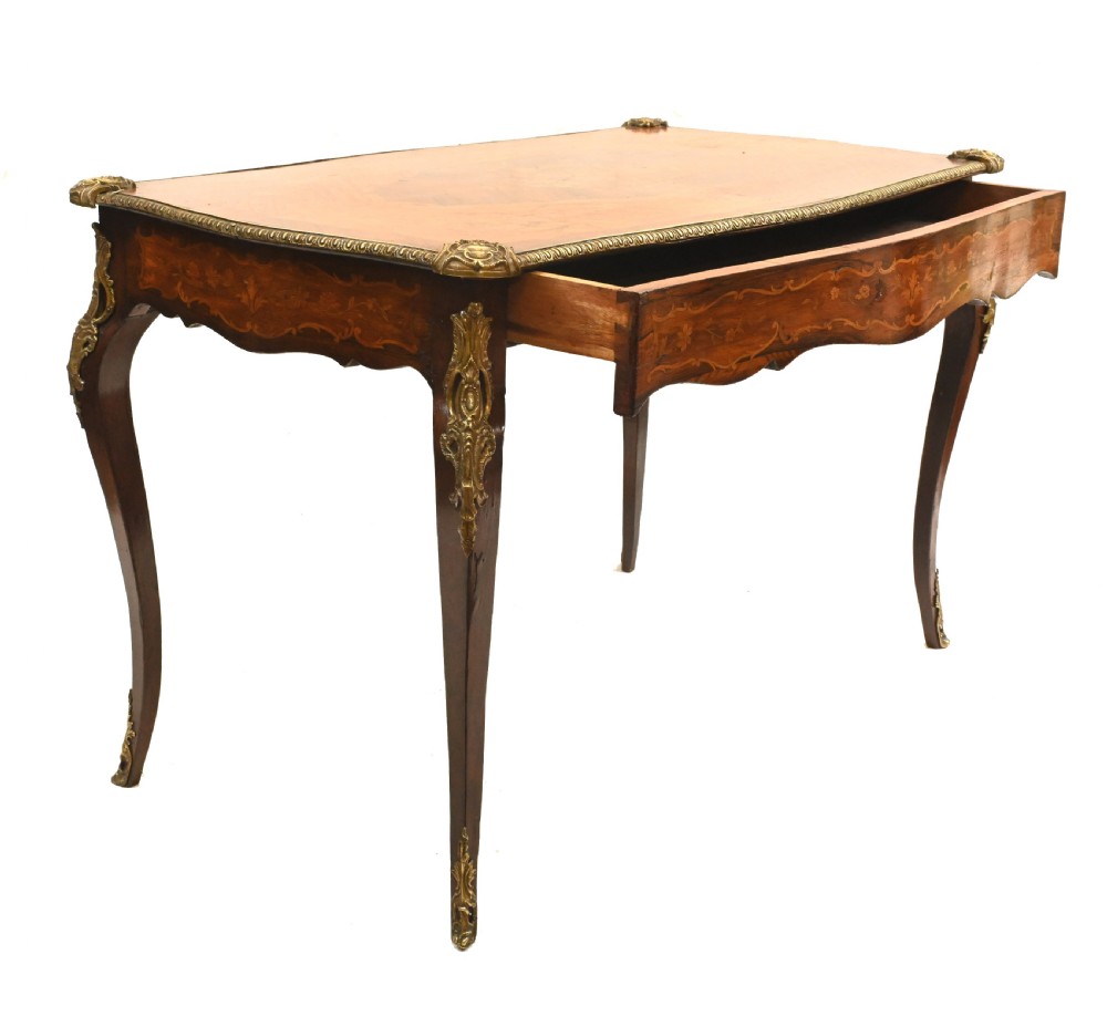 A French style writing table featuring floral marquetry wood veneers, cabriole legs, and ornate gilt-bronze mounts. View VII