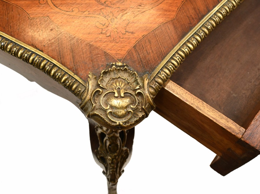 A French style writing table featuring floral marquetry wood veneers, cabriole legs, and ornate gilt-bronze mounts. View VIII