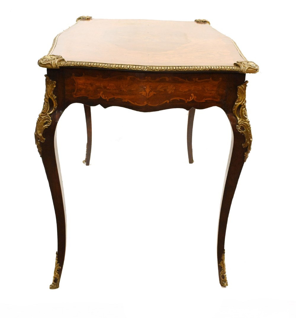 A French style writing table featuring floral marquetry wood veneers, cabriole legs, and ornate gilt-bronze mounts. View IX