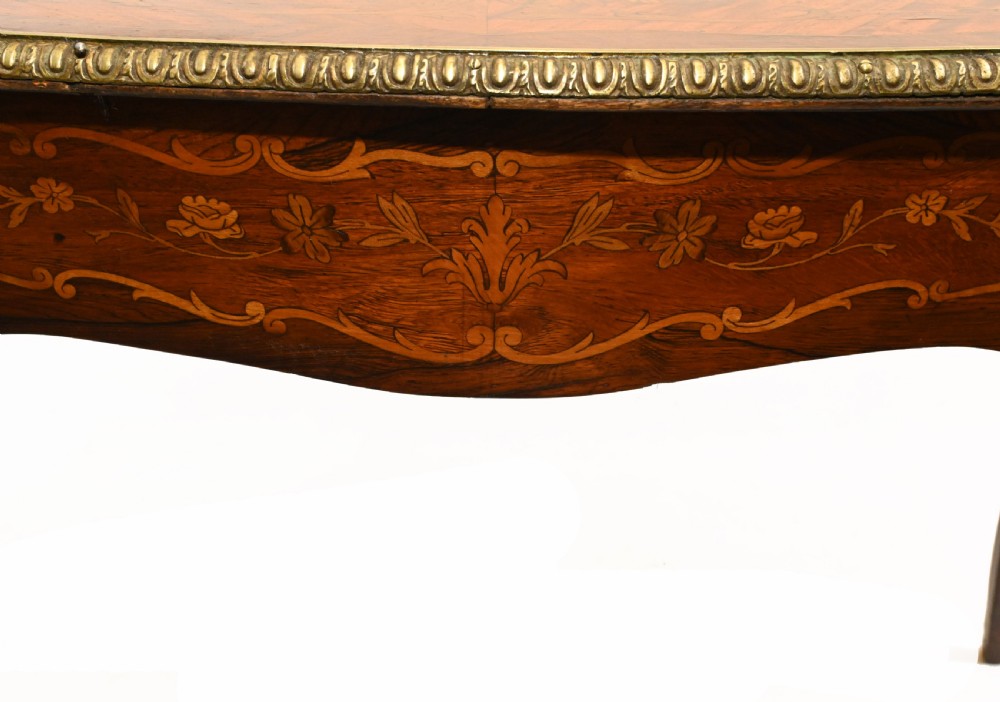 A French style writing table featuring floral marquetry wood veneers, cabriole legs, and ornate gilt-bronze mounts. View XI