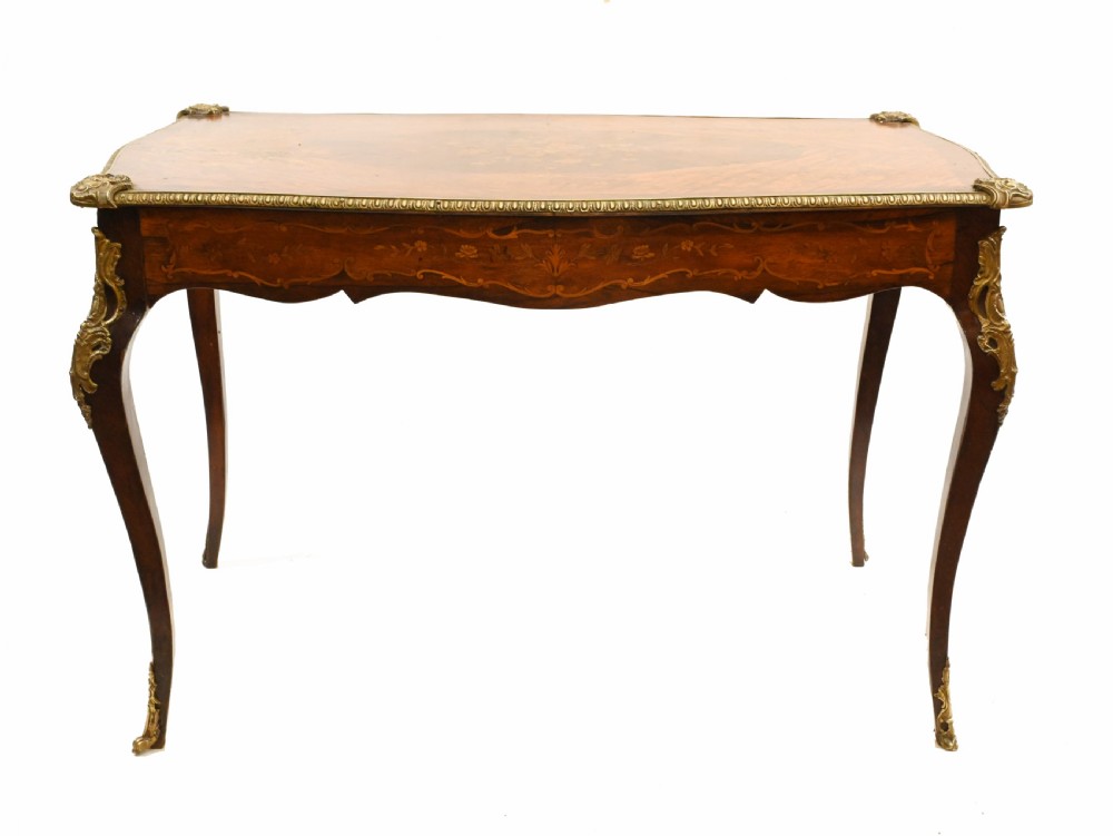 A French style writing table featuring floral marquetry wood veneers, cabriole legs, and ornate gilt-bronze mounts. View XII