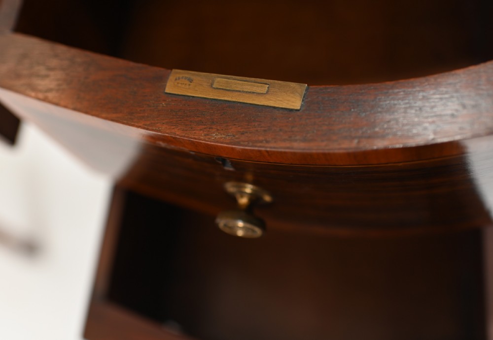 An Edwardian mahogany kidney-shaped writing desk featuring a brass gallery top, inlaid drawers, black leather writing inserts, and tapered legs. View XI