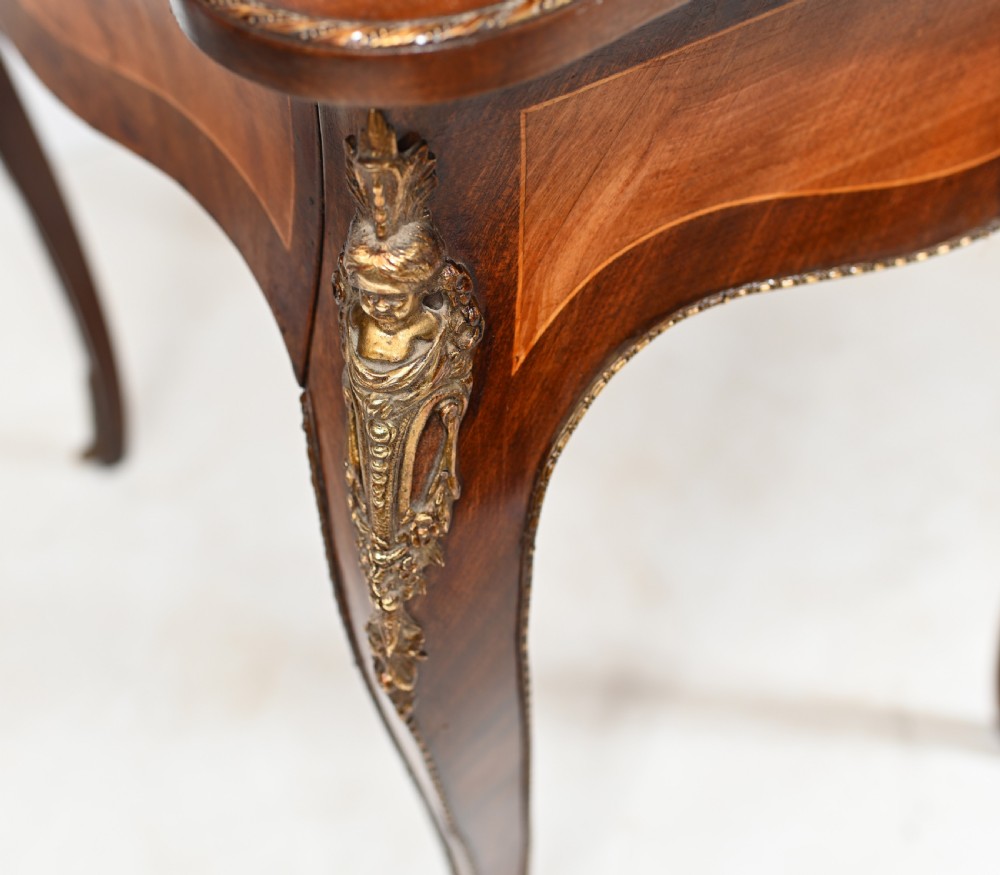 A French Louis XV style kingwood bonheur de jour desk featuring two upper cabinet doors inset with oval painted porcelain plaques, ornate metal mounts, and cabriole legs. View IX