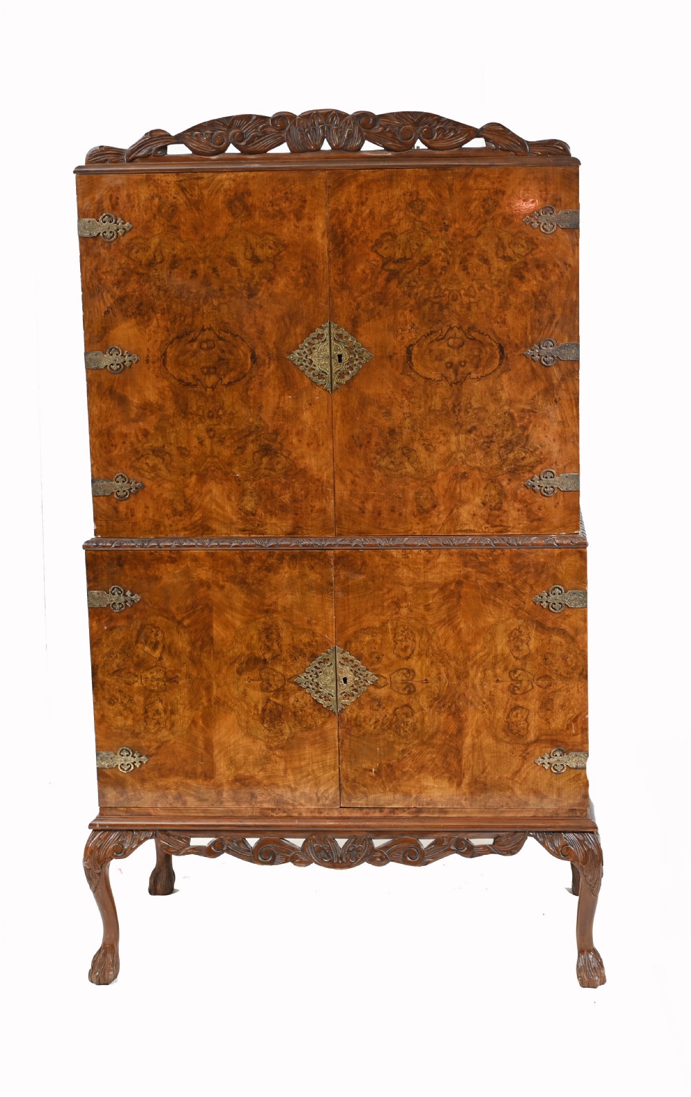 A two-tier Art Deco burr walnut cocktail cabinet featuring decorative brass strap hinges, lock plates, carved cresting, and cabriole legs. View II