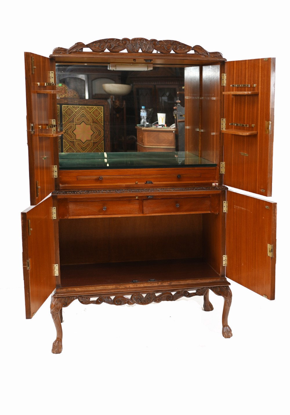 A two-tier Art Deco burr walnut cocktail cabinet featuring decorative brass strap hinges, lock plates, carved cresting, and cabriole legs. View VI