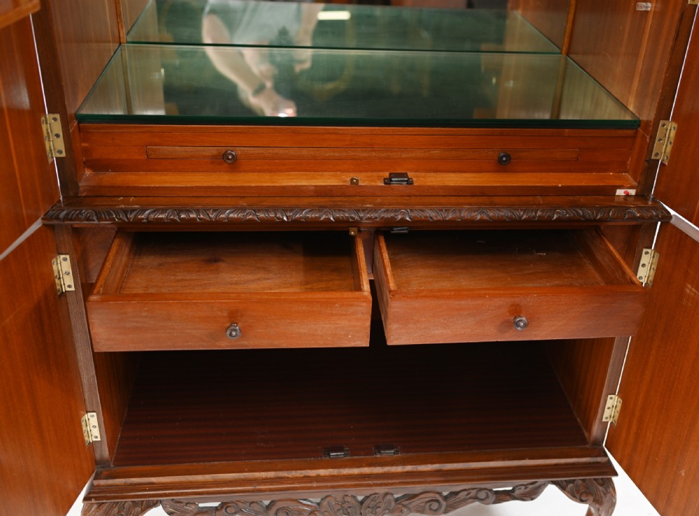 A two-tier Art Deco burr walnut cocktail cabinet featuring decorative brass strap hinges, lock plates, carved cresting, and cabriole legs. View VIII