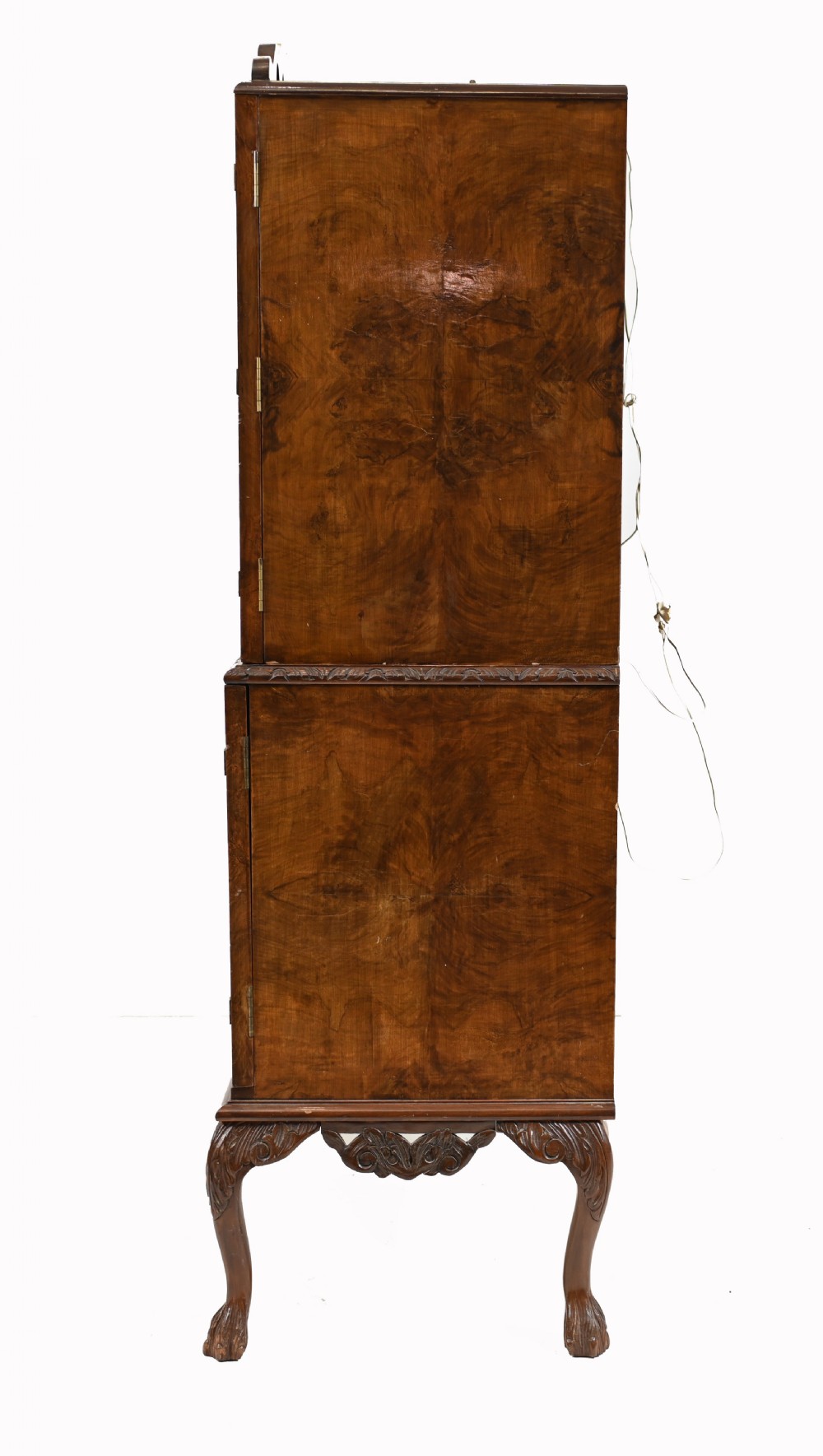 A two-tier Art Deco burr walnut cocktail cabinet featuring decorative brass strap hinges, lock plates, carved cresting, and cabriole legs. View X