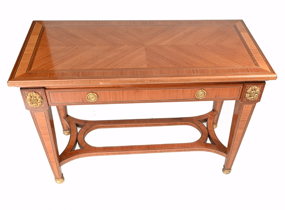 A pair of French Empire style mahogany console tables featuring satinwood crossbanding, gilt-bronze rosette mounts, and curved lower stretchers. View IV
