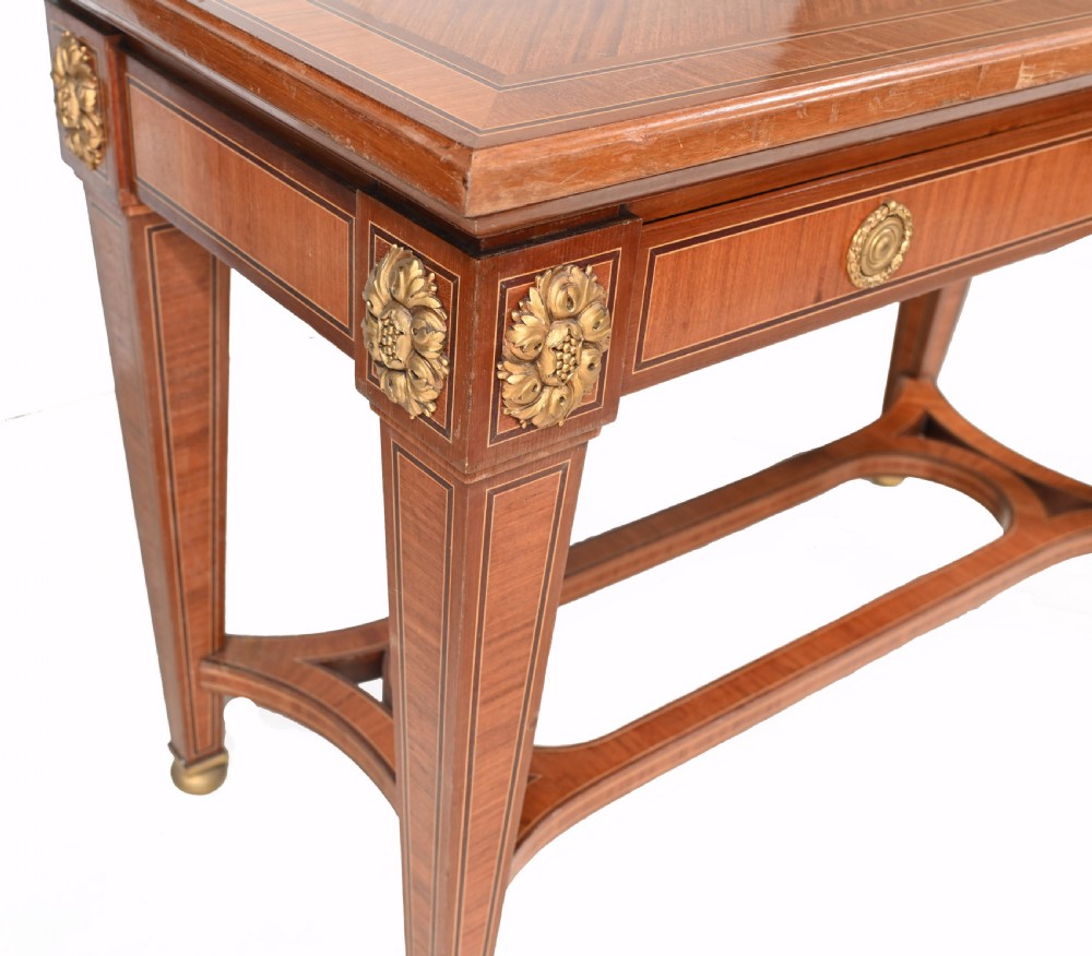 A pair of French Empire style mahogany console tables featuring satinwood crossbanding, gilt-bronze rosette mounts, and curved lower stretchers. View V