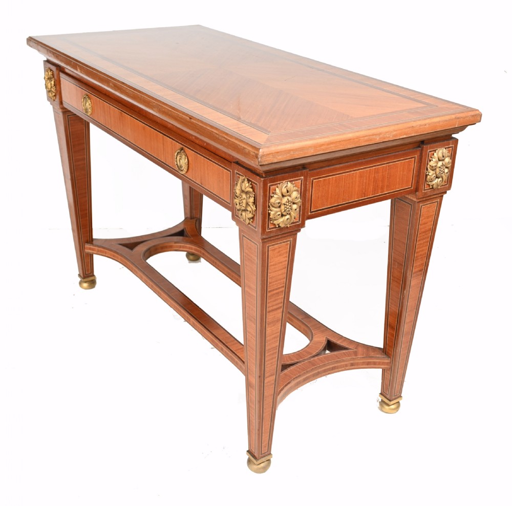 A pair of French Empire style mahogany console tables featuring satinwood crossbanding, gilt-bronze rosette mounts, and curved lower stretchers. View VII