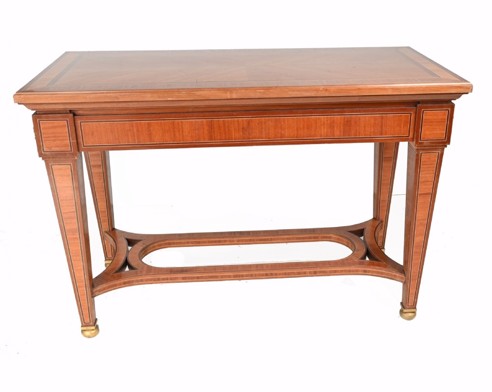 A pair of French Empire style mahogany console tables featuring satinwood crossbanding, gilt-bronze rosette mounts, and curved lower stretchers. View X