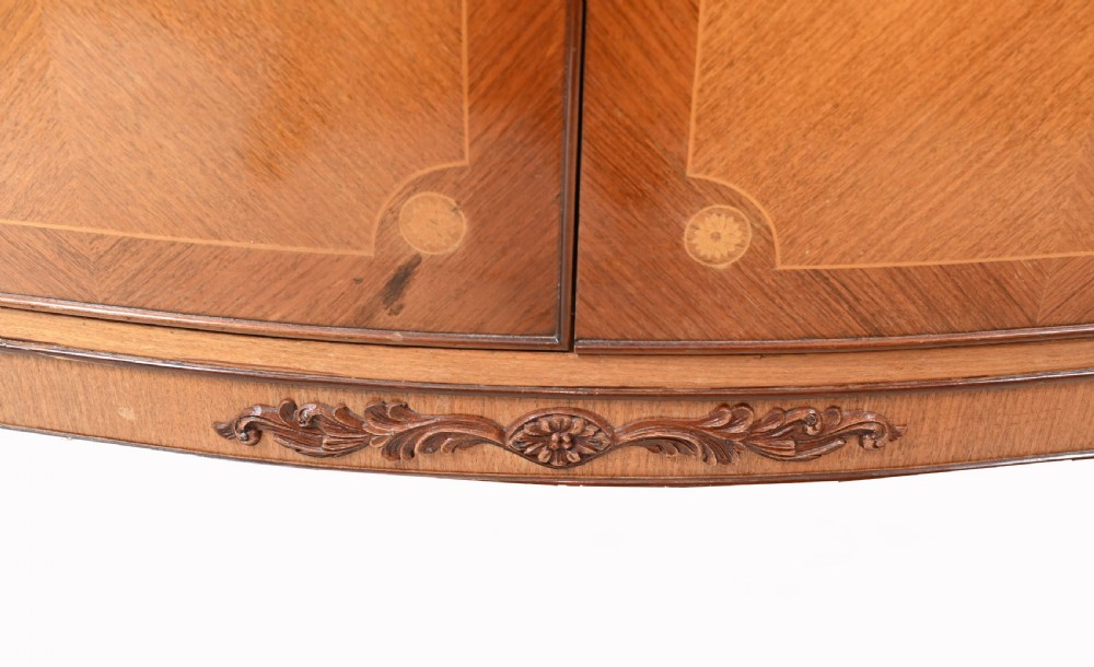 An Art Deco walnut drinks cabinet featuring floral marquetry panel doors, two central drawers, and carved cabriole legs. View V
