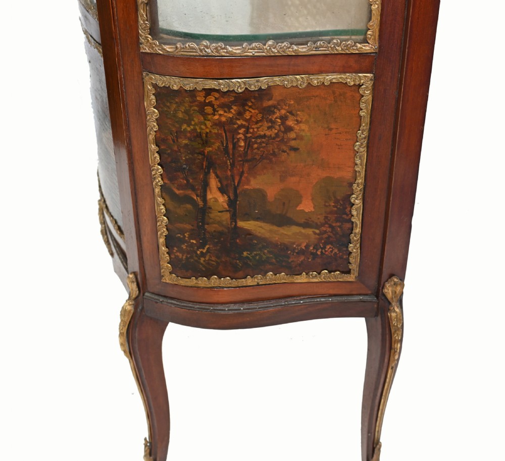 A French Vernis Martin style mahogany display cabinet featuring curved glass panels, gilt-bronze mounts, and a hand-painted pastoral scene on the lower door. View VII