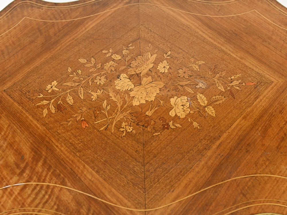 A French Louis XV style centre table featuring a serpentine top with floral marquetry inlay, slender cabriole legs, and metal mounts. View III