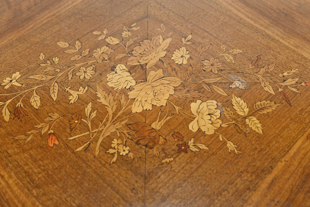 A French Louis XV style centre table featuring a serpentine top with floral marquetry inlay, slender cabriole legs, and metal mounts. View V