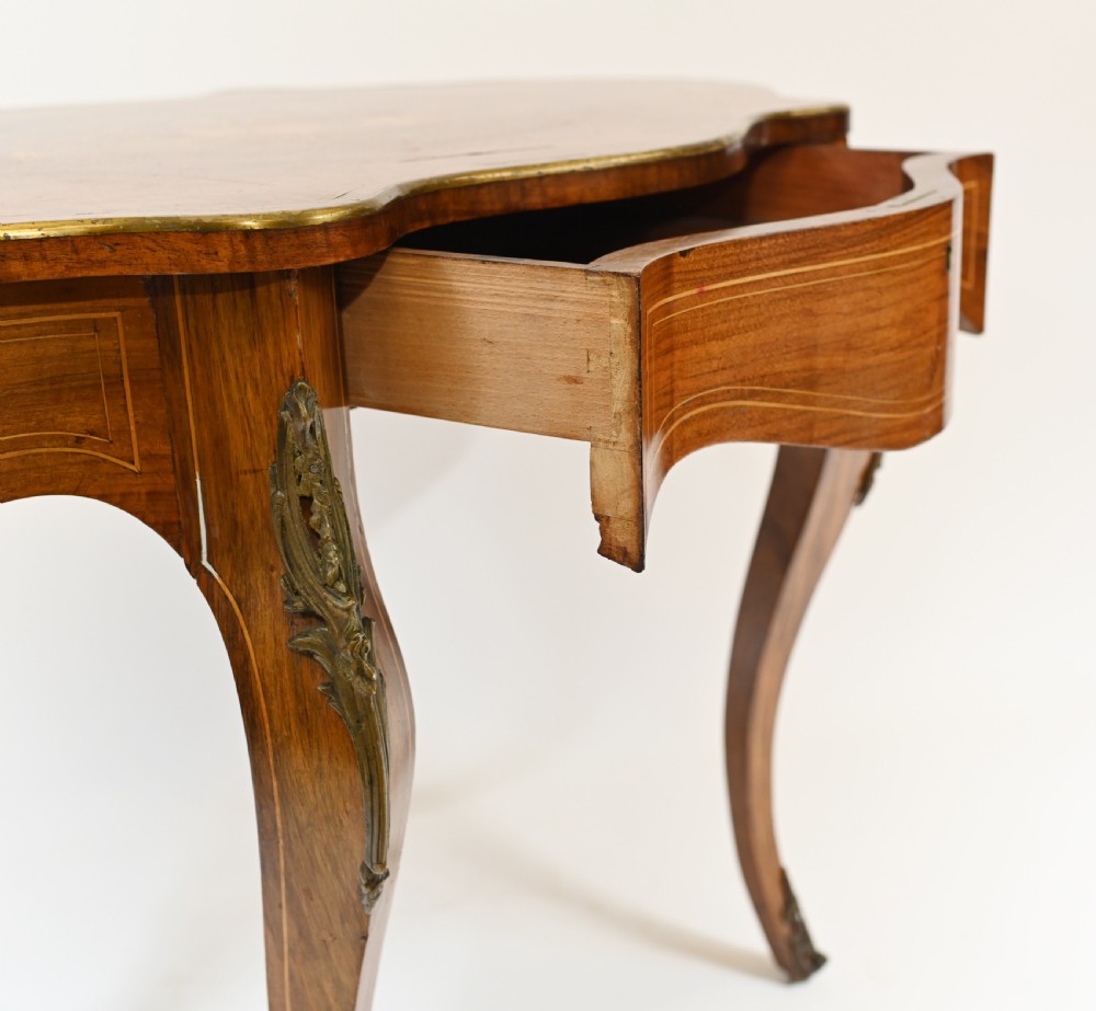A French Louis XV style centre table featuring a serpentine top with floral marquetry inlay, slender cabriole legs, and metal mounts. View VII