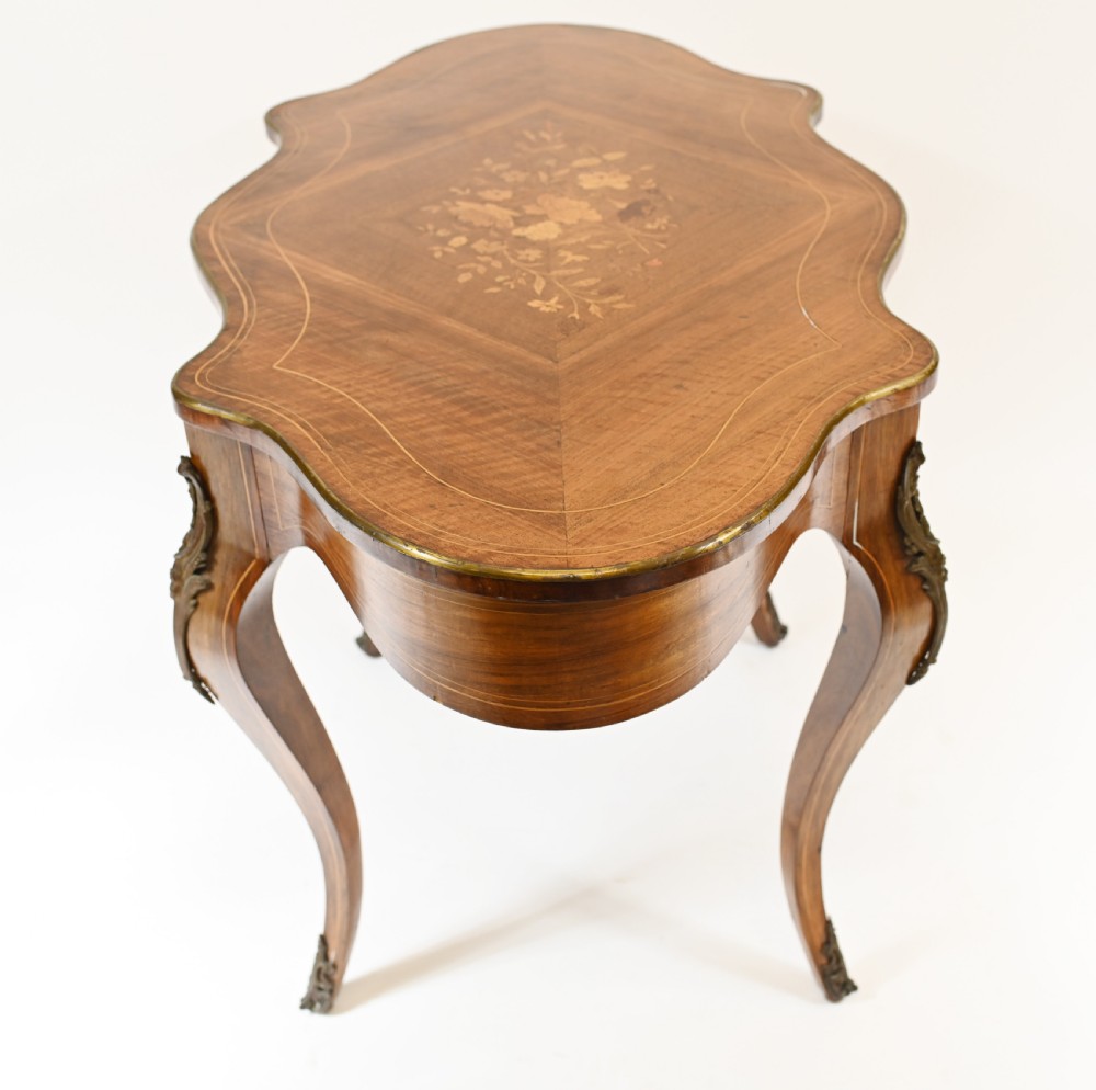 A French Louis XV style centre table featuring a serpentine top with floral marquetry inlay, slender cabriole legs, and metal mounts. View VIII
