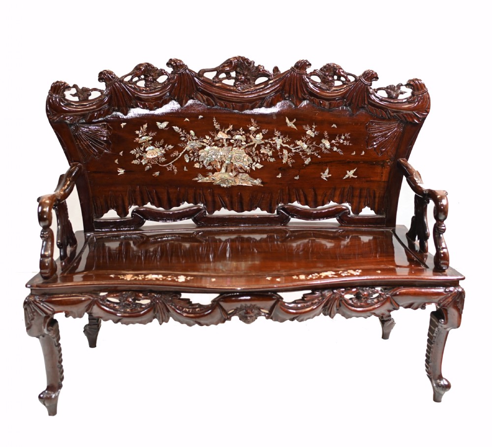 A three-piece dark hardwood seating suite comprising a double bench and two armchairs, decorated with mother of pearl floral inlays and carved detailing. View III