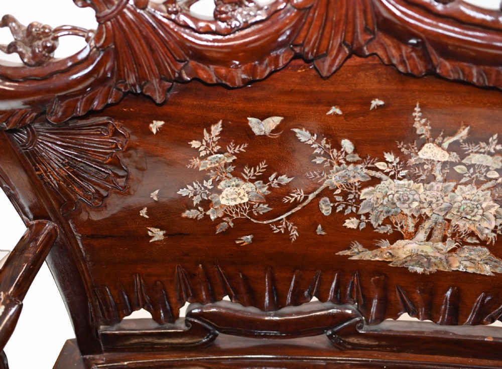 A three-piece dark hardwood seating suite comprising a double bench and two armchairs, decorated with mother of pearl floral inlays and carved detailing. View V