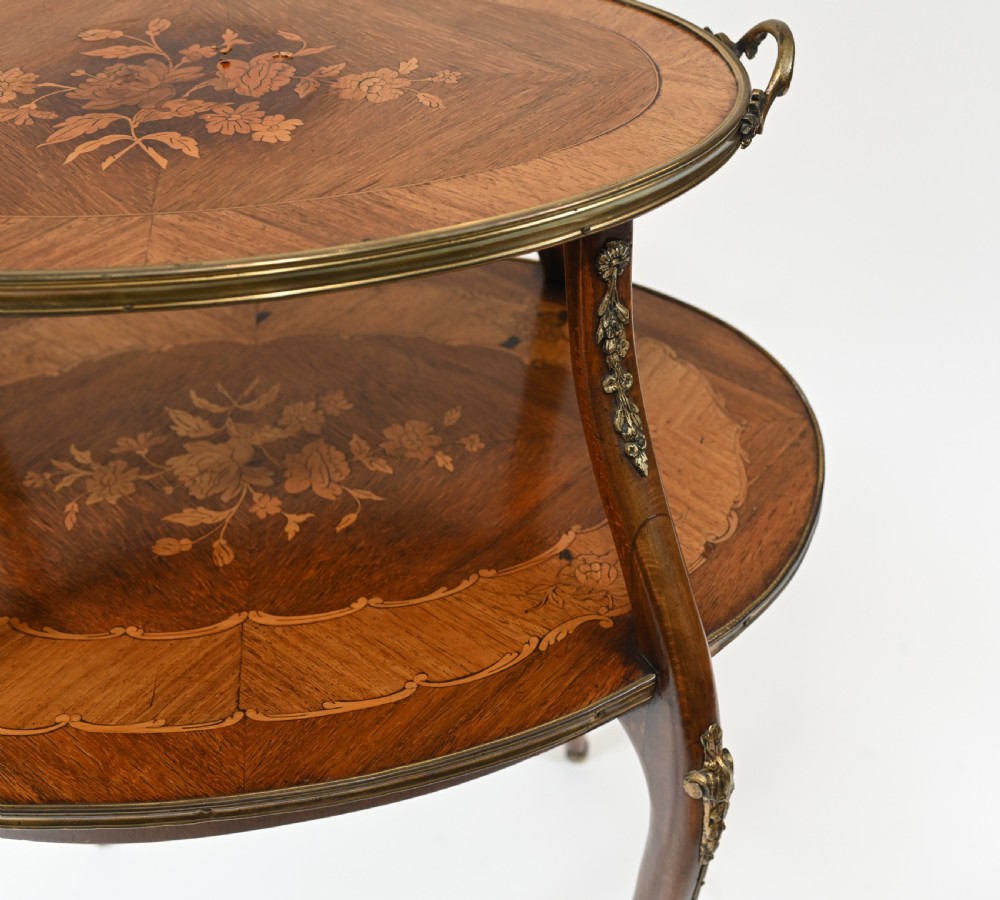An antique French two-tiered oval etagere side table featuring floral marquetry inlay, slender cabriole legs, and polished brass mounts. View IV