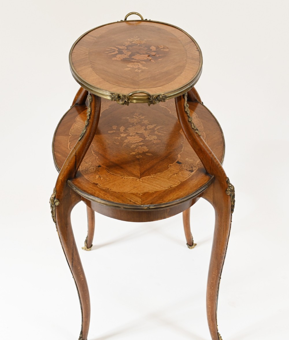 An antique French two-tiered oval etagere side table featuring floral marquetry inlay, slender cabriole legs, and polished brass mounts. View IX