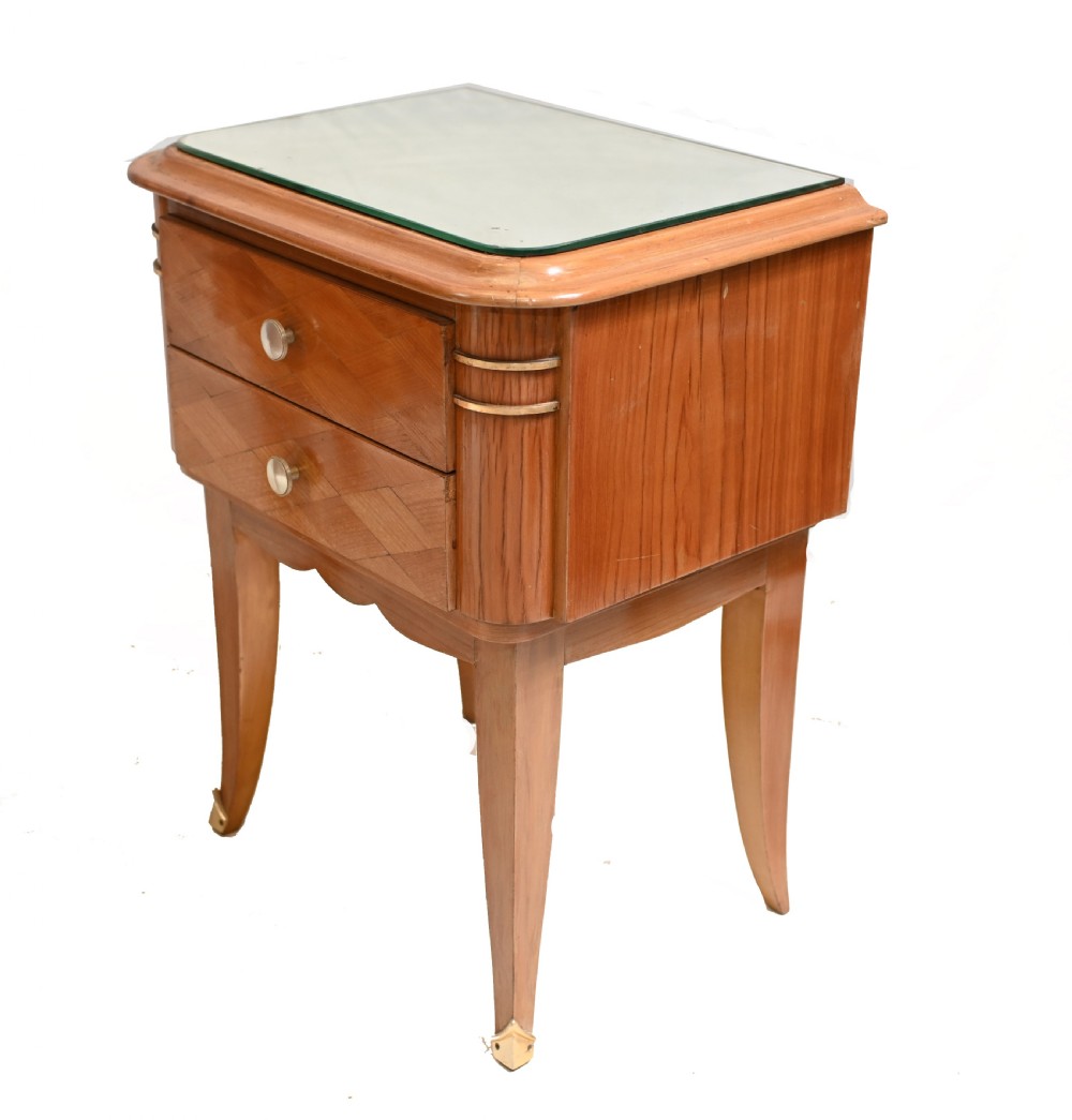 A pair of 1930s Art Deco wooden bedside cabinets featuring two drawers with diamond geometric veneers, rounded top edges with glass surface protectors, brass accents, and tapered legs. View II