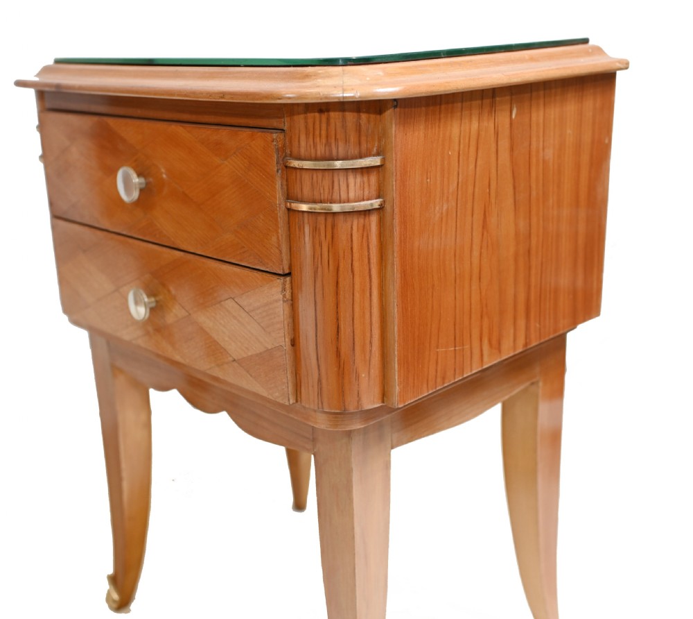 A pair of 1930s Art Deco wooden bedside cabinets featuring two drawers with diamond geometric veneers, rounded top edges with glass surface protectors, brass accents, and tapered legs. View IV