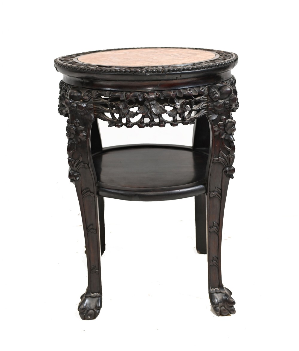 An antique Chinese dark hardwood side table featuring a circular inset marble top, openwork carved floral apron, lower tier, and carved legs. View II