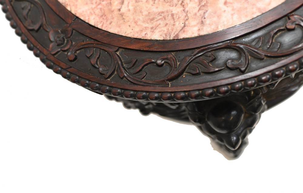 An antique Chinese dark hardwood side table featuring a circular inset marble top, openwork carved floral apron, lower tier, and carved legs. View VI