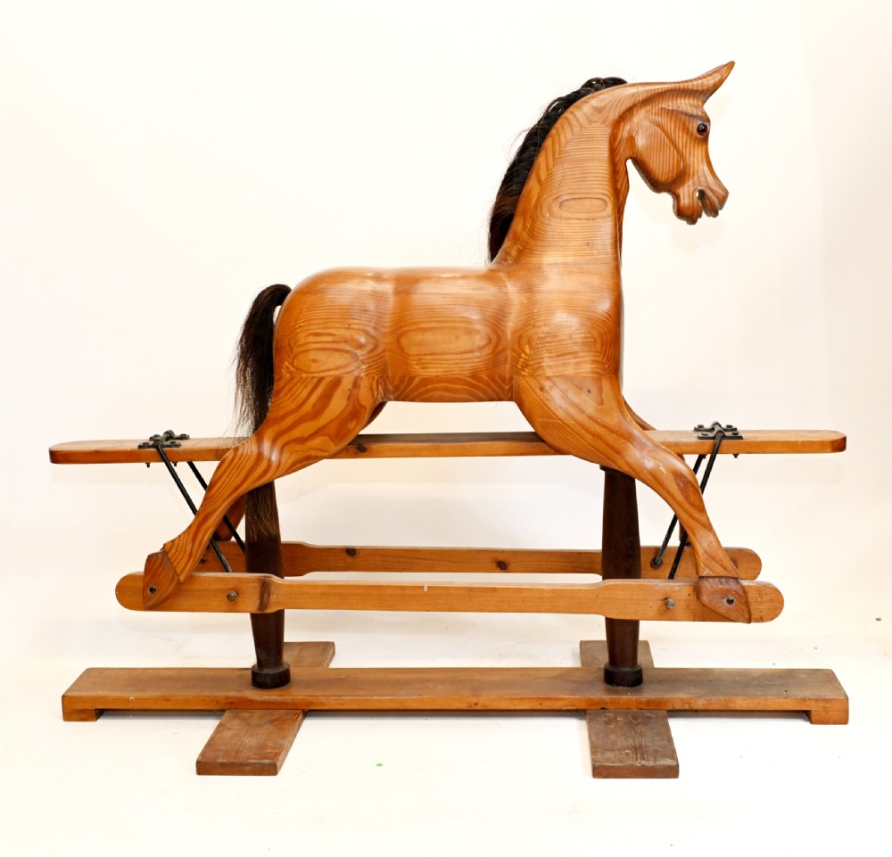 A hand-carved wooden rocking horse on a stationary wooden glider stand featuring a dark horsehair mane and tail. View IV