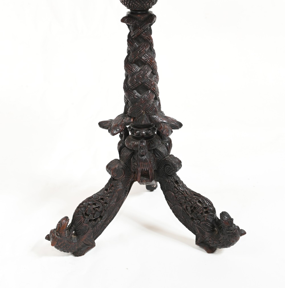 A circular 19th-century Burmese carved teak side table featuring intricate relief borders, a central plain top, a carved twisted stem, and tripod zoomorphic feet. View II