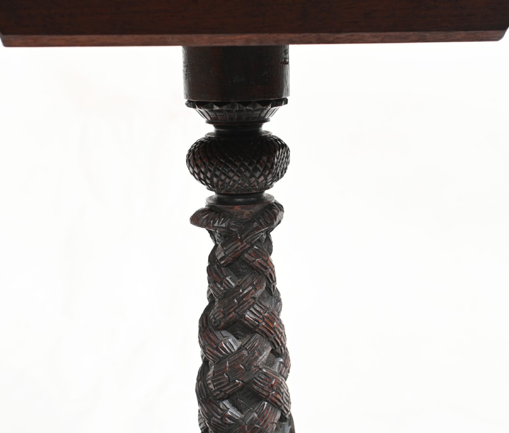 A circular 19th-century Burmese carved teak side table featuring intricate relief borders, a central plain top, a carved twisted stem, and tripod zoomorphic feet. View III