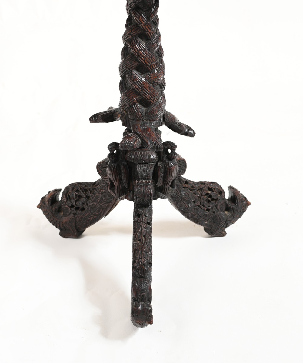 A circular 19th-century Burmese carved teak side table featuring intricate relief borders, a central plain top, a carved twisted stem, and tripod zoomorphic feet. View VI