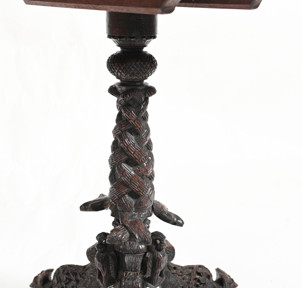 A circular 19th-century Burmese carved teak side table featuring intricate relief borders, a central plain top, a carved twisted stem, and tripod zoomorphic feet. View VII