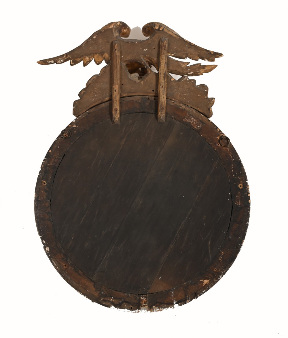 A circular Regency giltwood convex wall mirror topped with a carved eagle surmount and decorated with spherules around a black reeded slip. View VI